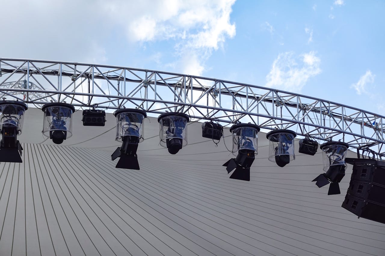 Overhead view of an outdoor stage with modern lighting setup against a blue sky.