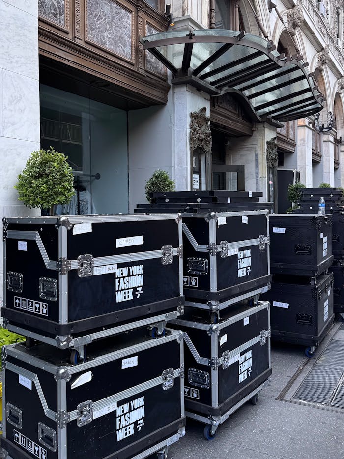 Stacked equipment cases on display outside a building for New York Fashion Week.