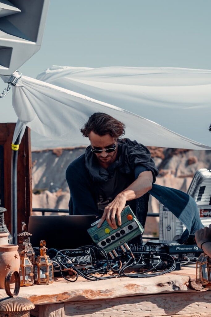 Crafting Captivating Headlines: Your awesome post title goes here A DJ playing electronic music at an outdoor event in Türkiye with scenic backdrop.